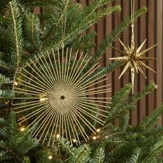 a star ornament hanging from the top of a christmas tree