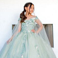 This New Addition Is Designed To Make Your Little One Feel Like A Princess, Combining Elegance, Whimsy, And Delightful Details. Crafted With Love And Attention To Detail, This Gown Features A Long Length That Adds A Touch Of Grandeur And Elegance. The Floor-Length Skirt Cascades Down, Creating A Mesmerizing Effect As Your Child Glides Through The Room. They Will Feel Like They're In A Fairy Tale With Every Step They Take. Length: Long Color: Sage Neckline: Off Shoulder Silhouette: Ball Gown Slee