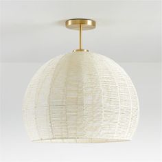 a white and gold light fixture with a circular shade on the top, hanging from a ceiling