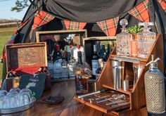 an outdoor bar set up with bottles and glasses