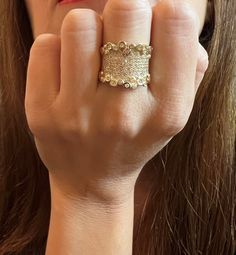 a woman is holding her hand up to her face with a ring on it's finger