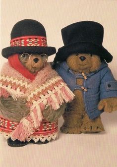 two teddy bears dressed in clothes and hats