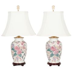 two lamps with flowers on them sitting next to each other and one lamp has a white shade