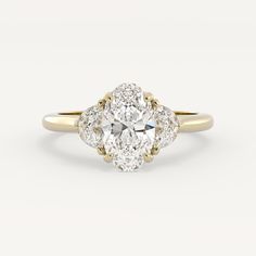 an oval cut diamond ring with three pear shaped diamonds on the shoulders and sides, in yellow gold