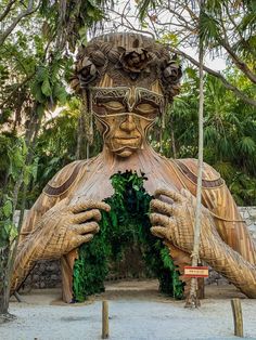 a large wooden statue in the middle of a forest