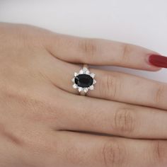 a woman's hand with a black and white diamond ring on her left hand