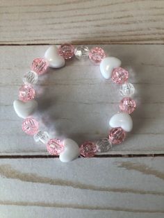 This is a Valentine Heart Bracelet. It would make a cute gift for a little girl for Valentines Day. It would make a cute gift for a little girl's Birthday. It has five heart beads. It has pink and clear 8mm faceted beads. It was made with.8mm sturdy stretch string. It fits girls ages 5-8. It stretches to fit on the wrist. All items are ready to be shipped I do combined shipping. Items ship in 2-5 business days. Check out more items at: http://www.etsy.com/shop/MesheleCrafts  https://www.facebook Bracelets Kids, Girls Bracelets, Valentines Bracelets, Bracelet Heart, Kids Bracelets, Bracelet Beaded, Plastic Beads, Heart Beads, Valentine Heart