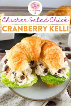 chicken salad sandwich with cranberry kell on a plate next to some croissants