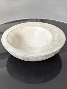 a white bowl sitting on top of a black table