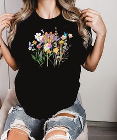 This  colorful wildflower unisex  shirt is perfect for hot summer days. With wildflowers, butterfly and a dragonfly ♥ PRODUCTION TIME: 1-5 days (Usually 2-3 days) ♥ SHIPPING TIME: 2-5 days (Usually 3 days) ♥ PRODUCT DESCRIPTION:   Our Relaxed Fit Tee (Bella + Canvas style 3001) is a unisex style that runs a touch small for men, and about a half a size large for women. It's a relaxed fit and is soft and cozy. * For T-shirt Sizes Please refer to the Listing Image. ♥ CARE INSTRUCTION: Machine wash: Multicolor Summer Shirt With Plant Print, Multicolor Plant Print Shirt For Summer, Multicolor Shirt With Plants Print For Summer, Summer Cotton Shirt With Butterfly Print, Butterfly Print Short Sleeve Tops For Spring, Short Sleeve Tops With Butterfly Print For Spring, Casual Butterfly Print Shirt For Spring, Spring Butterfly Print Crew Neck Shirt, Botanical Style Shirt With Relaxed Fit For Summer