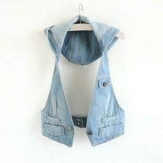 a denim vest hanging on a white wall