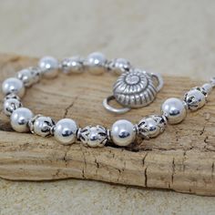 Elevate your boho chic style with this lovely beachy accessory featuring a stunning Thai conch shell closure. This handcrafted beaded bracelet combines the beauty of bohemian design with coastal style. Alternating sterling silver round beads are capped with Bali sterling silver and finished with an S-style Thai clasp. Orders ship Monday - Friday via US First Class mail. Processing time is 1 - 2 days; most items ship the same day. Thank you for choosing BeadedMoonJewery for your jewelry needs. If you hav questions or customization requests, please feel free to message me. I take pride in providing high-quality, unique pieces that you'll cherish for years to come. Bohemian Pearl Bracelet For Summer, Summer Bohemian Pearl Bracelet, Handmade Bohemian Pearl Bracelet For Summer, Adjustable Silver Beaded Bracelets For Beach, Bohemian Silver Beads Jewelry For Beach, Bohemian Pearl Bracelet For Beach With Round Beads, Adjustable Silver Bohemian Pearl Bracelet, Bohemian Pearl Bracelet With Round Beads For Beach, Adjustable Silver Pearl Bohemian Bracelet