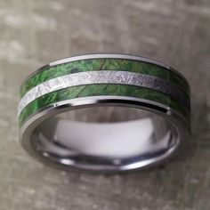 a wedding band with green and silver inlays