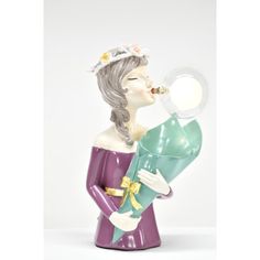 a figurine holding a baby in her arms and drinking from a magnifying glass