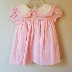 "- This gorgeous vintage dress is ready to be worn again! It is pink gingham with short sleeves and buttons at back of neck. There is a large, round collar trimmed in gingham ruffles. The white on collar is embroidered with pink flowers with greens and a bow. So perfect for Easter. size is: 9 months (2 available) Length: 13.75\" + 3\" hem allowance" Short Sleeve Gingham Smock Dress, Short Sleeve Checkered Plaid Dress With Ruffles, Plaid Smocked Short Sleeve Dress, Short Sleeve Plaid Smock Dress, Sweet Gingham Dress With Ruffles, Classic Gingham Short Sleeve Dress, Classic Short Sleeve Gingham Dress, Classic Gingham Dress With Short Sleeves, Cute Gingham Dress With Short Sleeves