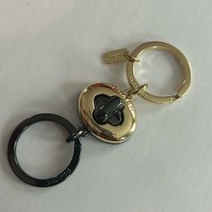 a heart shaped keychain with a black and gold ring on it's side