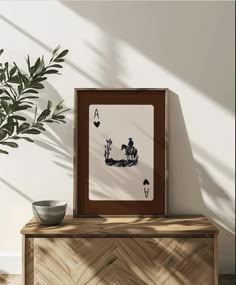 a table with a vase and a card on it next to a potted plant