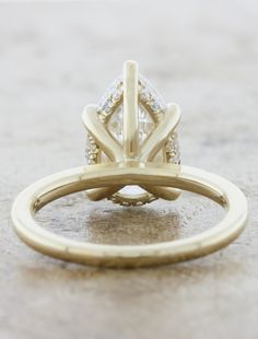 a yellow gold engagement ring with two diamonds on the side and an open band around it