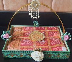 an elaborately decorated box on display with beads and pearls hanging from it's sides