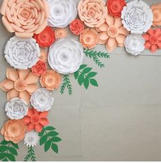 an arrangement of paper flowers is displayed on the wall