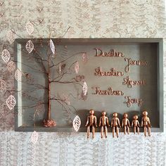 a group of wooden figurines sitting on top of a shelf next to a tree