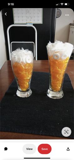 two glasses filled with liquid sitting on top of a table