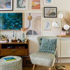 a living room filled with lots of pictures on the wall above a chair and ottoman