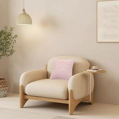 a chair with a pink pillow on it next to a potted plant and lamp