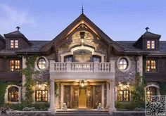 a large house with lots of windows and lights on it's front entrance area