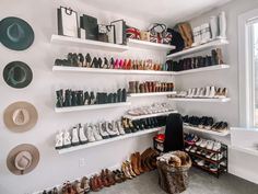 there are many shoes and hats on the shelves in this room, all lined up against the wall