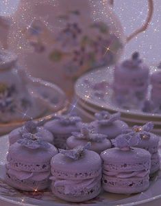 purple frosted pastries on a plate with teapots in the background