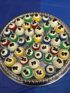 cupcakes are arranged in the shape of numbers on a cake platter that sits on a blue tablecloth