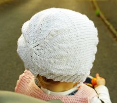 a small child wearing a white knitted hat