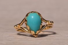 The Sandpiper Lane: Vintage Mid Century Yellow Gold Turquoise Ring. At the core of this design rests a pear-shaped cabochon with a mesmerizing robins egg blue turquoise, securely cradled within Fleur de Lis inspired prongs. Below the center stone, a graceful split shank elegantly merges, adorned with intricate granulations at its peak. Meticulously fashioned from 14-karat yellow gold, this ring captures the essence of the mid-century era with a touch of timeless beauty. Presently sized at 4.5, t Elegant Turquoise Teardrop Rings, Elegant Turquoise Teardrop Ring For Anniversary, Mid Century Yellow, Gold Turquoise Ring, Turquoise Gold Ring, Heart Pendant Diamond, Robins Egg, Robins Egg Blue, Split Shank