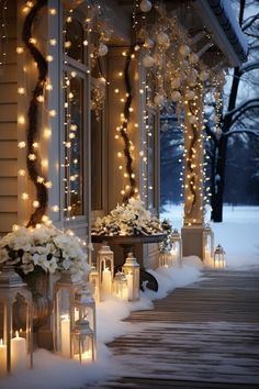 christmas lights are hanging from the side of a house in front of flowers and lanterns