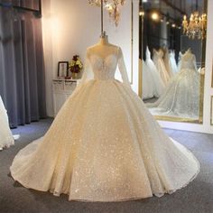 a white wedding dress on display in front of a mirror with other dresses behind it