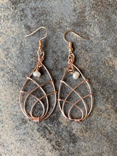 Experience timeless elegance with our meticulously handcrafted rose gold colored wire drop earrings. The delicate woven and open oval design captures both sight and touch, creating an exquisite tactile sensation. Adorned with lustrous freshwater pearls, these earrings sway gracefully, reflecting light and movement. Elevate your style and invite compliments with this embodiment of beauty. Crafted from coated craft wire that will never tarnish. Elegant Rose Gold Wire Wrapped Earrings, Elegant Copper Wire Drop Earrings, Elegant Teardrop Copper Wire Earrings, Elegant Rose Gold Copper Wire Jewelry, Elegant Rose Gold Earrings With Copper Wire, Elegant Copper Wrap Earrings, Rose Gold Wire Wrapped Earrings, Elegant Copper Teardrop Earrings, Rose Gold Wire Wrapped Earrings In Copper