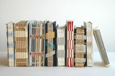 a stack of books sitting next to each other on top of a white tablecloth covered floor