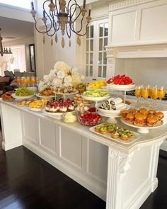 a table filled with lots of food on top of a hard wood floored kitchen