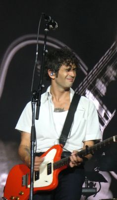 a man with a red guitar on stage