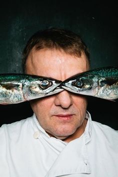 a man with two fish on his eyes looking through the hole in front of him