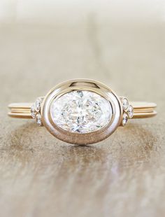 a close up of a ring with a diamond on it's center and two smaller diamonds in the middle