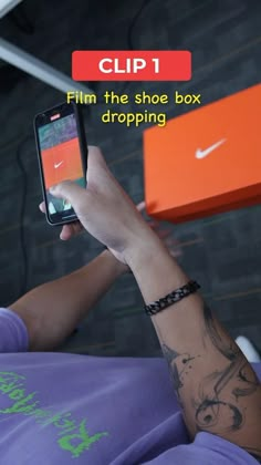 a person holding a cell phone in their hand with the text clip 1 film the shoe box dropping