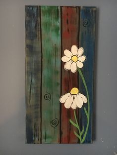 a painting with two flowers painted on the side of a wooden planks wall hanging