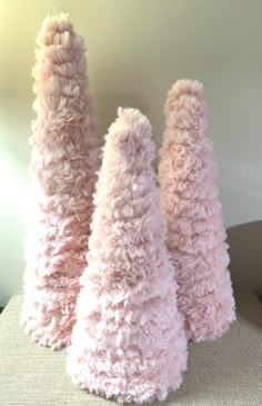 three pink vases sitting on top of a chair