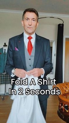 a man in a suit and tie standing next to a couch with the words fold a shirt in 2 seconds