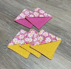 four pieces of fabric with flowers on them sitting on a wooden floor next to each other