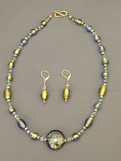 "This set uses some of my favorite beads  bought on the Island of Murano and hoarded by me for years. They are real gold inside with a light blue glass overlay that makes them appear almost green. They are alternated with light green freshwater pearls, blue luster Czech fire polish rounds, and gold bead caps. The necklace is 20\" long with gold vermeil clasp; the earrings are 1.75 \" long, including the gold-plated lever- back wires." Glass Overlay, Murano Glass Necklaces, Murano Glass Jewelry, Buy Bead, Classic Necklace, Murano Glass Beads, Cat Earrings, Gold Glass, Traditional Jewelry