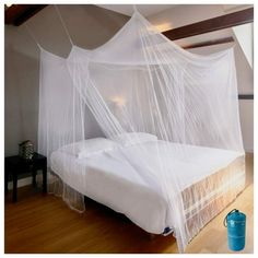 a white bed with mosquito netting over it