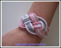 a close up of a person's arm wearing a bracelet made out of crochet